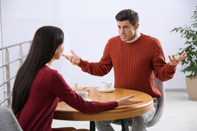 Photo of Couple having quarrel in cafe. Relationship problems