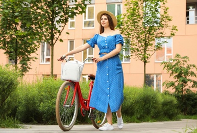 Young pretty woman with bicycle in city