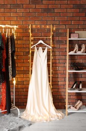 Photo of White beautiful women's party dress and shoes in showroom. Stylish trendy clothes for high school prom