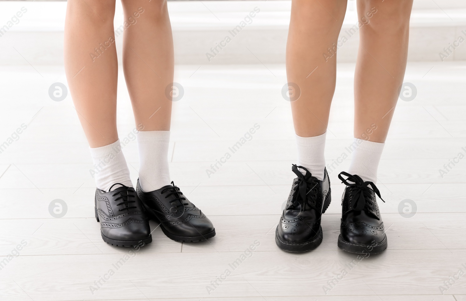 Photo of Girls in stylish school uniform indoors, focus on legs
