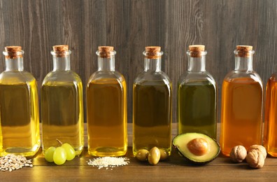 Vegetable fats. Different oils in glass bottles and ingredients on wooden table