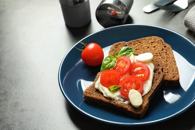 Photo of Toast bread with cherry tomatoes and mozzarella cheese on table