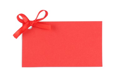 Blank red gift tag with satin ribbon on white background, top view