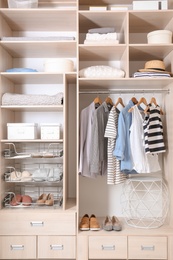 Photo of Stylish clothes, shoes and home stuff in large wardrobe closet