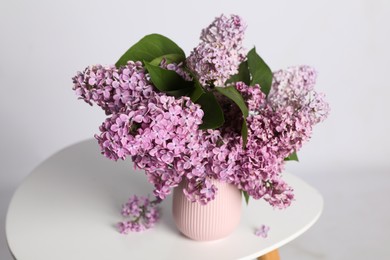 Beautiful lilac flowers in vase on white table