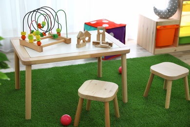 Photo of Stylish playroom interior with toys and modern wooden furniture