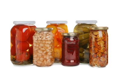 Glass jars of different pickled vegetables isolated on white