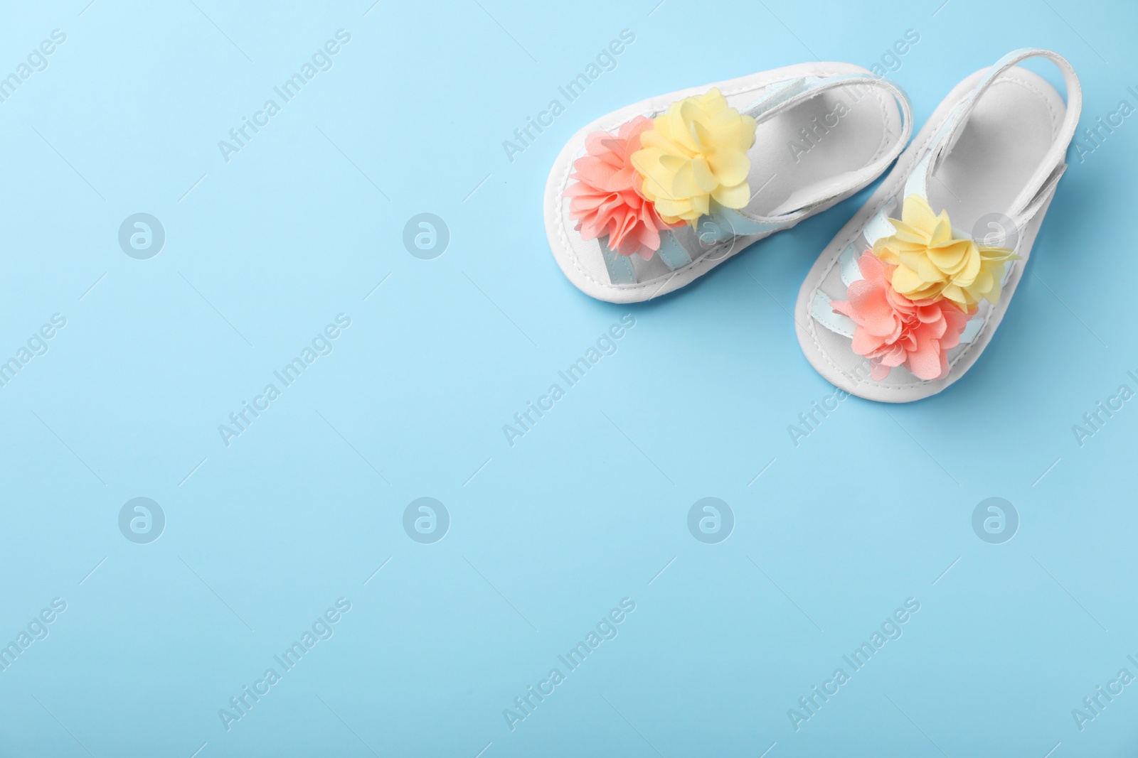 Photo of Pair of cute baby sandals on color background, top view