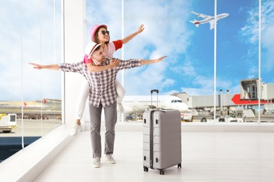 Image of Happy young couple with suitcase in airport