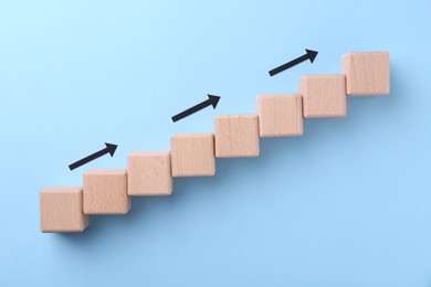 Photo of Business process organization and optimization. Scheme with wooden figures and arrows on light blue background, top view