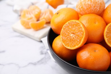Photo of Fresh juicy tangerines on white marble table, closeup. Space for text