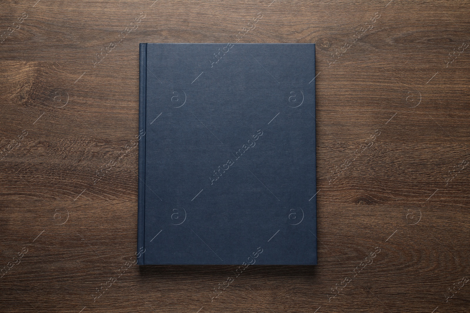 Photo of Closed hardcover book on wooden table, top view