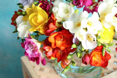 Photo of Beautiful spring bright freesia flowers on stand, closeup