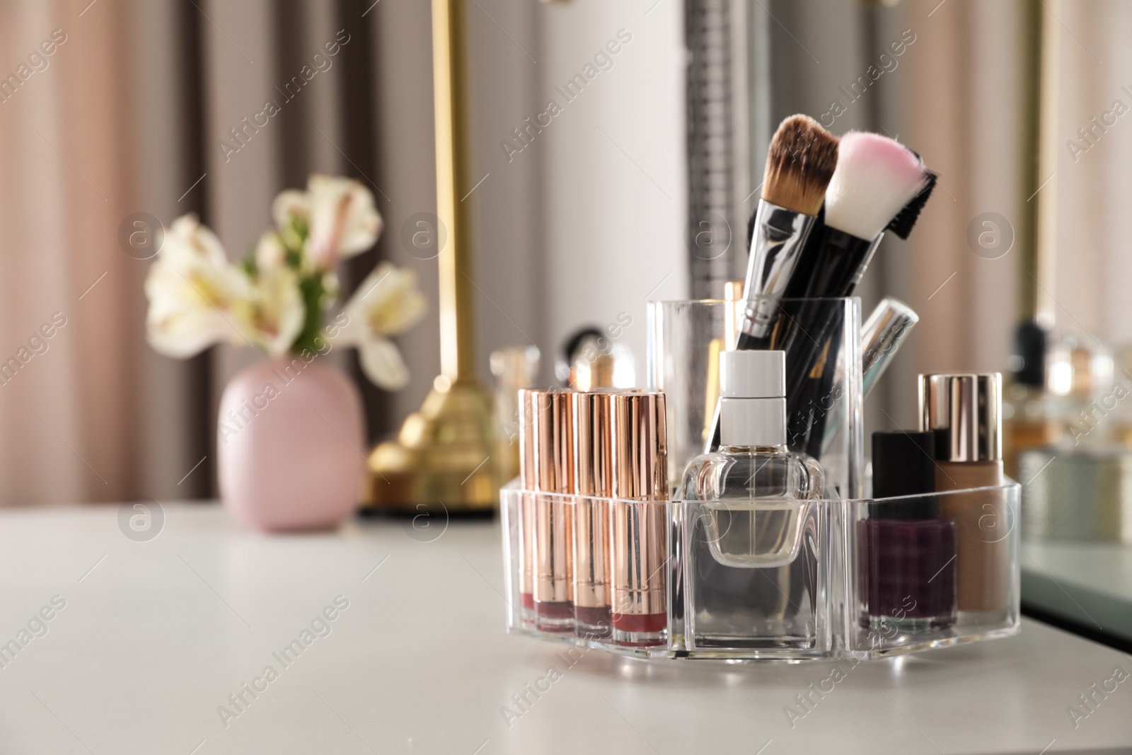 Photo of Luxury makeup products and accessories on dressing table with mirror. Space for text