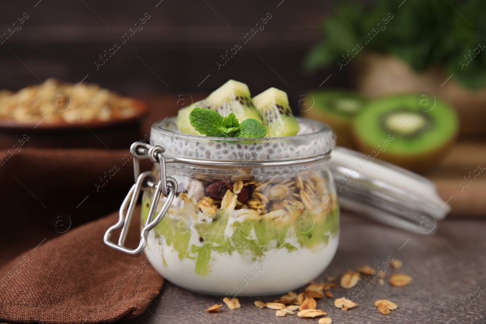 Photo of Delicious dessert with kiwi and chia seeds on brown table, closeup