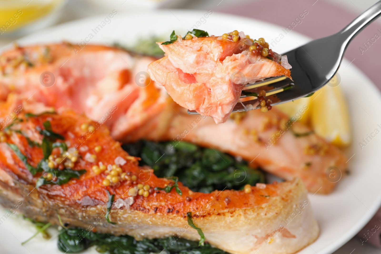 Photo of Tasty salmon with spinach on plate, closeup