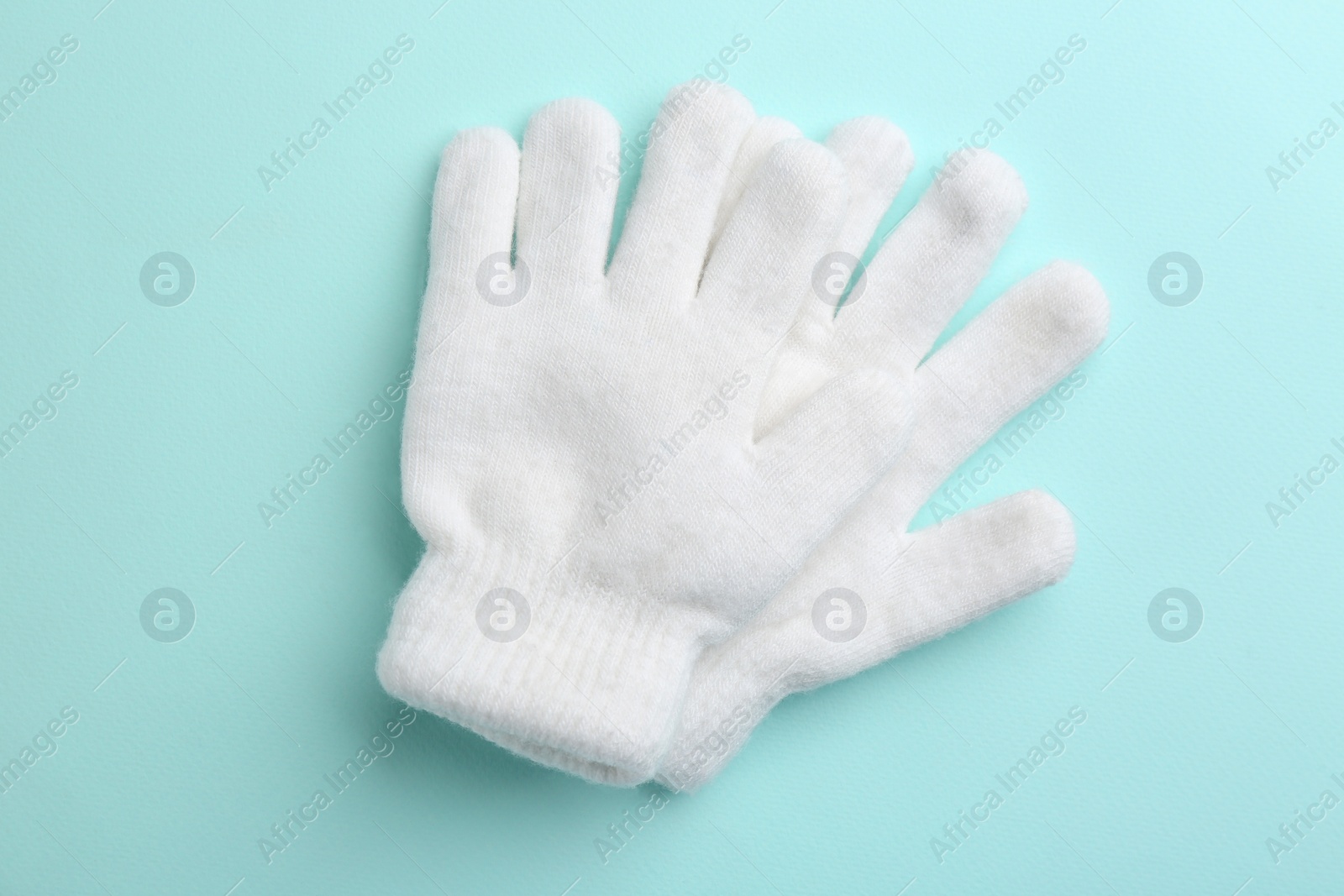 Photo of Pair of stylish woolen gloves on light blue background, flat lay