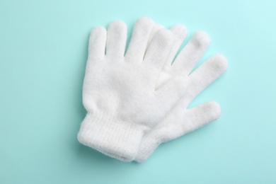 Pair of stylish woolen gloves on light blue background, flat lay