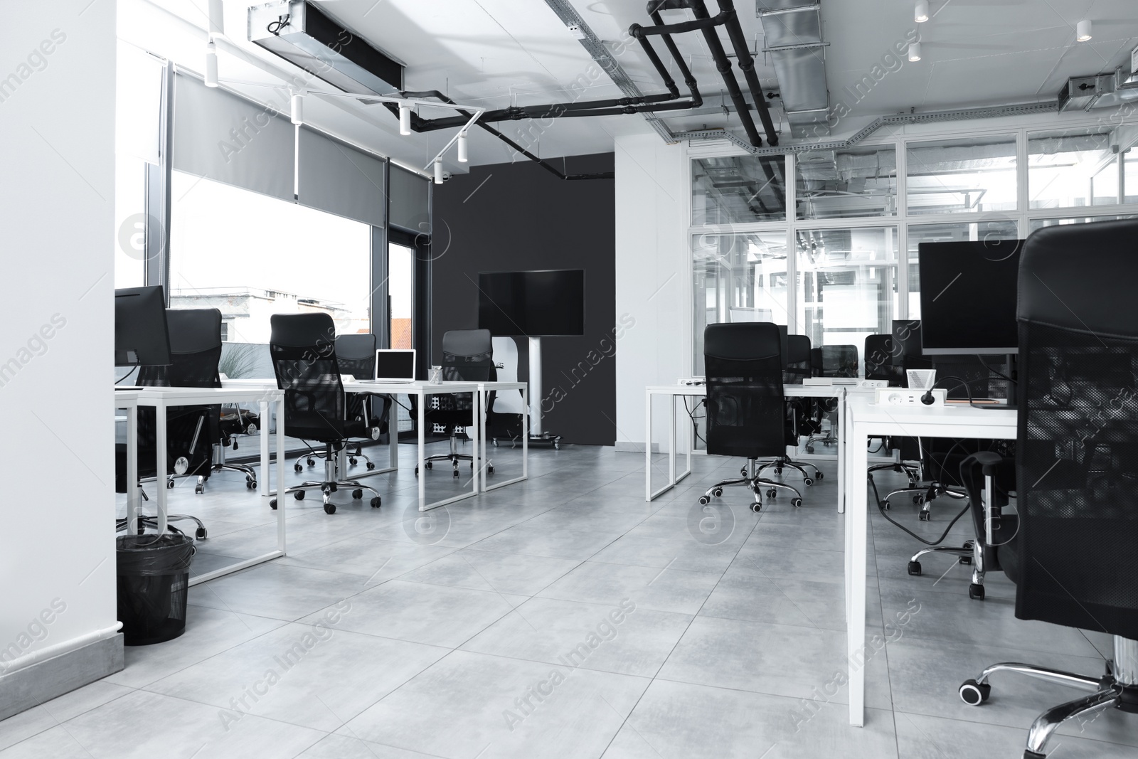 Photo of Stylish interior of open plan office. Workspace with tables and chairs