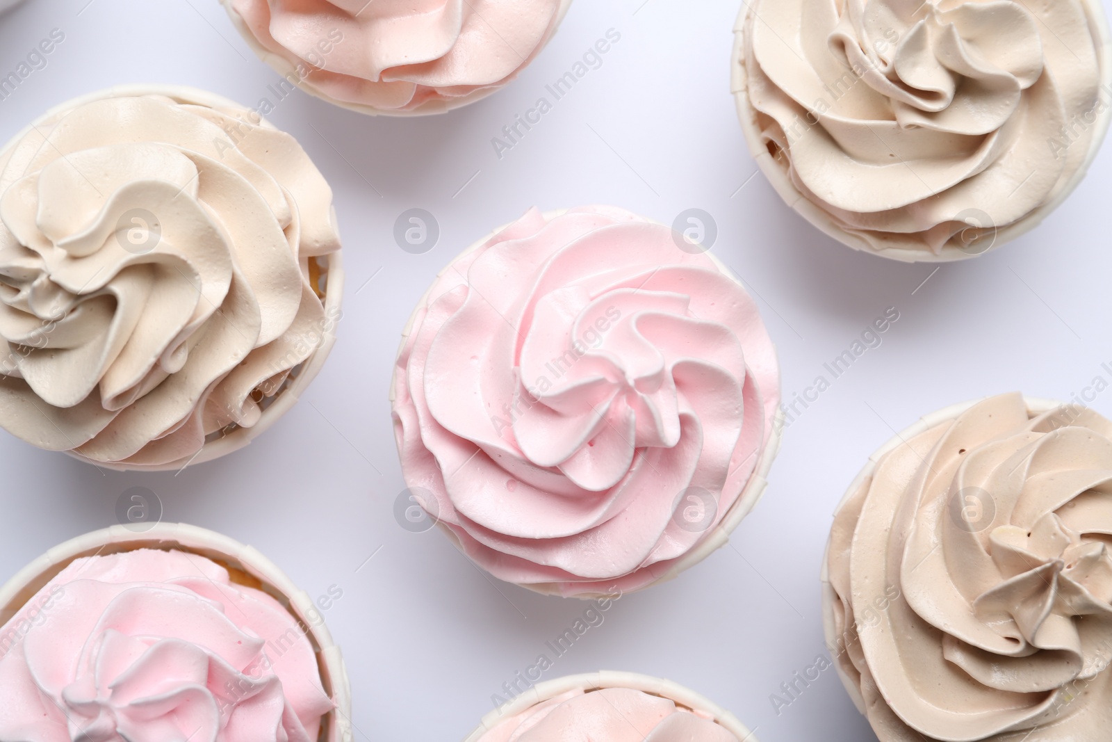 Photo of Many tasty cupcakes on white background, flat lay