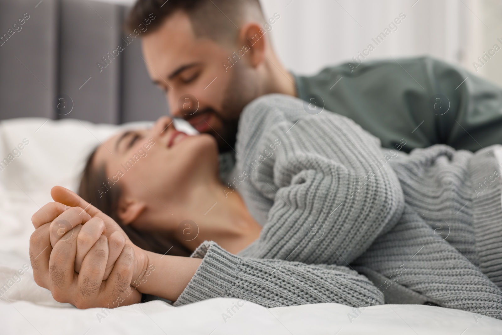Photo of Affectionate young couple spending time together on bed, selective focus
