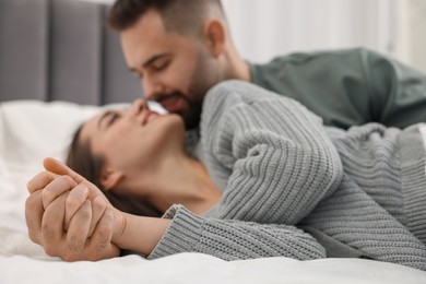 Photo of Affectionate young couple spending time together on bed, selective focus