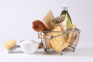 Set of different cleaning supplies in basket on white background