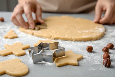 Photo of Young woman preparing Christmas cookies on table