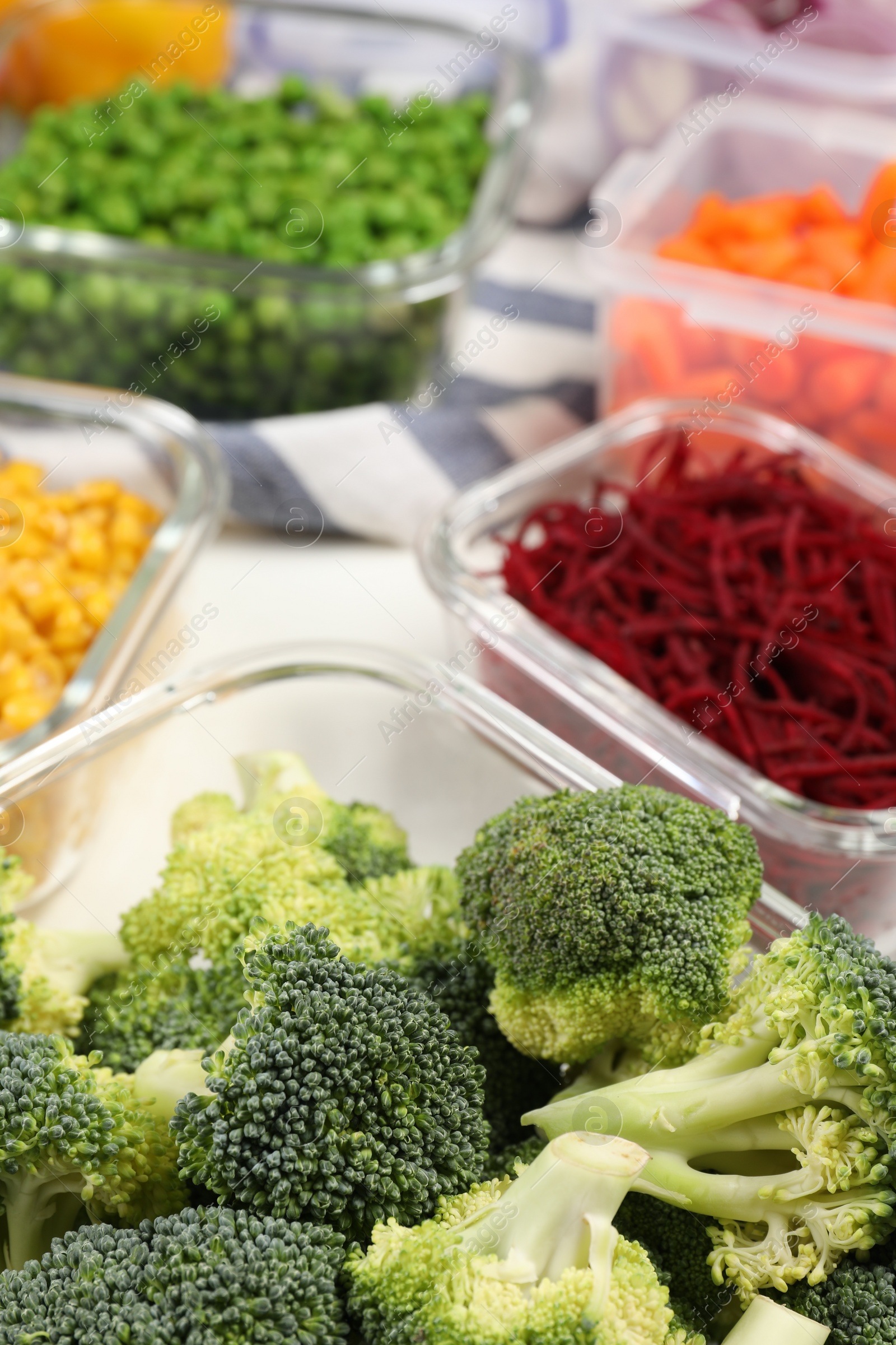 Photo of Containers with broccoli and fresh products on table, closeup. Food storage