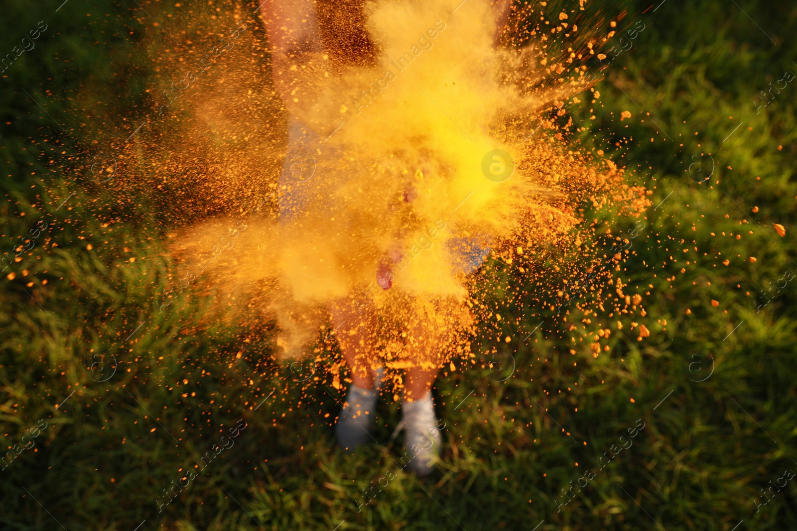 Photo of Woman with orange powder dye outdoors, closeup. Holi festival celebration