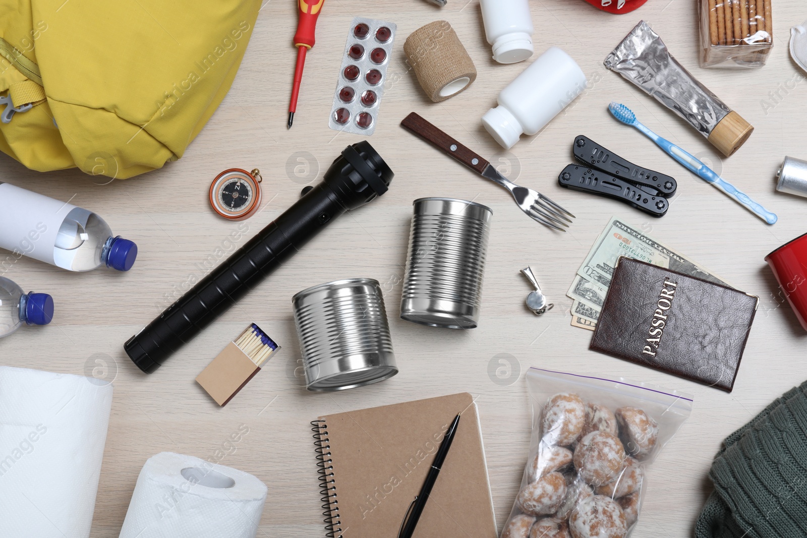 Photo of Disaster supply kit for earthquake on wooden table, flat lay