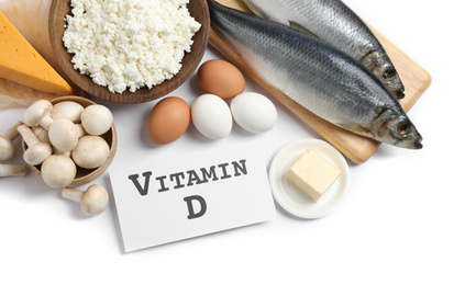 Photo of Paper with phrase VITAMIN D and fresh products on white background, top view