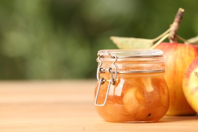 Delicious apple jam and fresh fruit on wooden table. Space for text