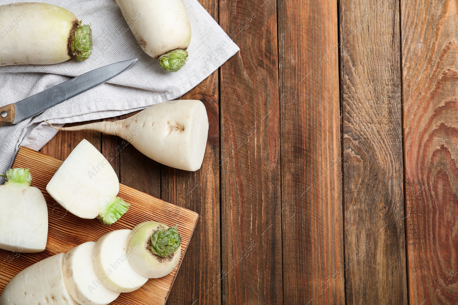 Photo of White turnips on wooden table, flat lay. Space for text