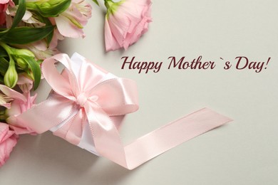 Image of Happy Mother's Day greeting card. Beautiful flowers and gift box on beige background