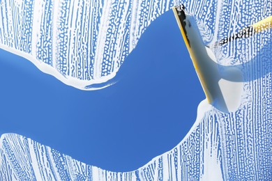 Squeegee and cleaning foam on glass, closeup