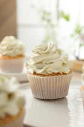 Photo of Tasty cupcakes with vanilla cream on table, closeup