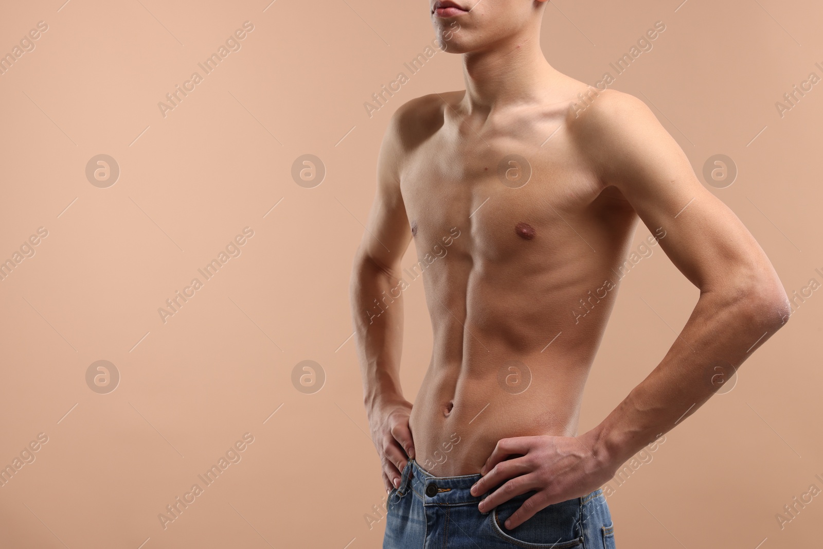 Photo of Shirtless man with slim body on beige background, closeup. Space for text