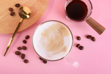 Cup of fresh coffee and beans on pink table, flat lay