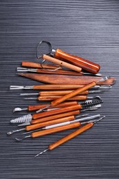 Photo of Set of clay crafting tools on black table, flat lay