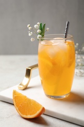 Photo of Delicious orange soda water in glass on tray