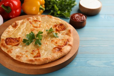 Photo of Delicious khachapuri with cheese on light blue wooden table, space for text