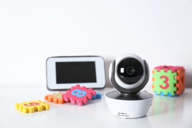 Modern CCTV security camera, monitor and child puzzle on table against white background. Space for text