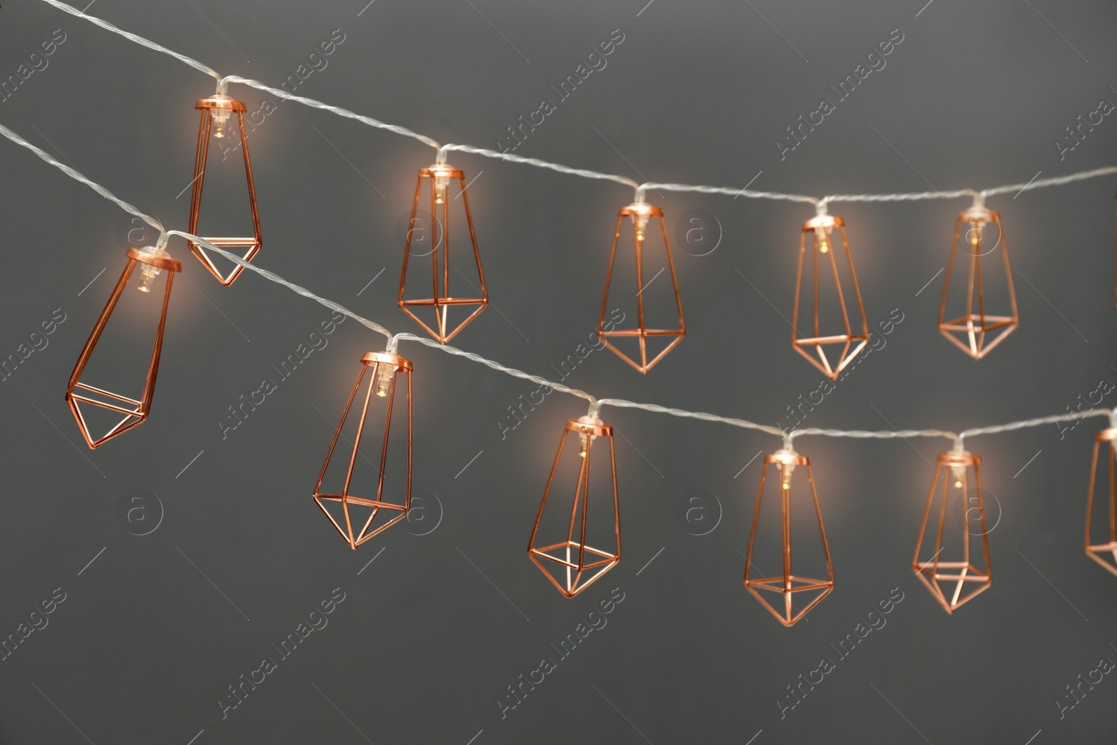 Photo of Garlands of lamps with light bulbs on grey background