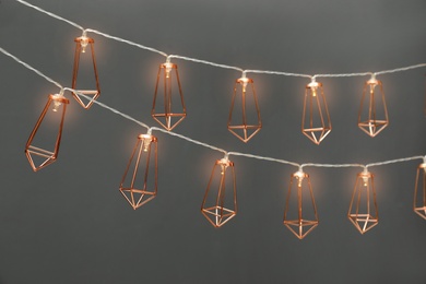 Photo of Garlands of lamps with light bulbs on grey background