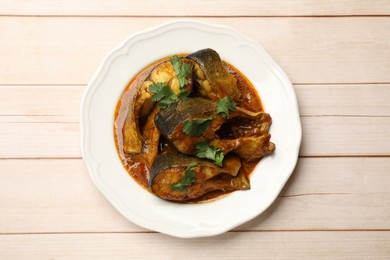 Tasty fish curry on white wooden table, top view. Indian cuisine