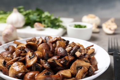 Photo of Plate of fried mushrooms on table, closeup