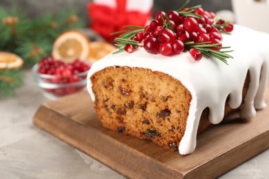 Photo of Traditional classic Christmas cake decorated with cranberries, pomegranate seeds and rosemary on table, closeup