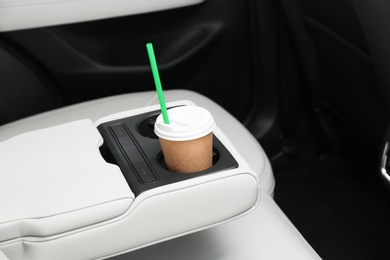 Photo of Takeaway paper coffee cup in holder inside car