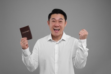 Photo of Immigration. Excited man with passport on grey background